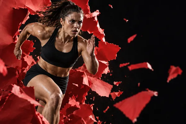 Runner breaking through red paper