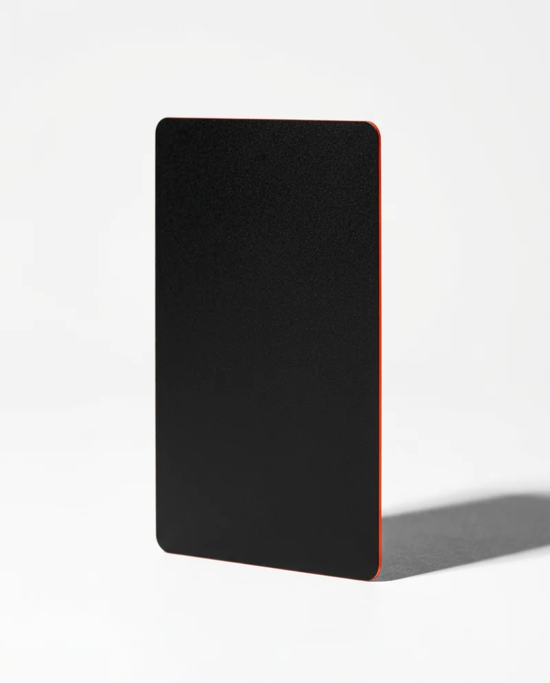 Black payment card with a red edge casting a long shadow