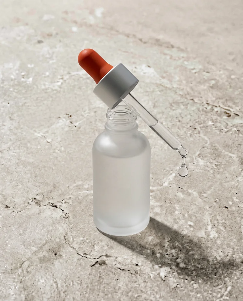Serum bottle with a red dropper and a falling drop
